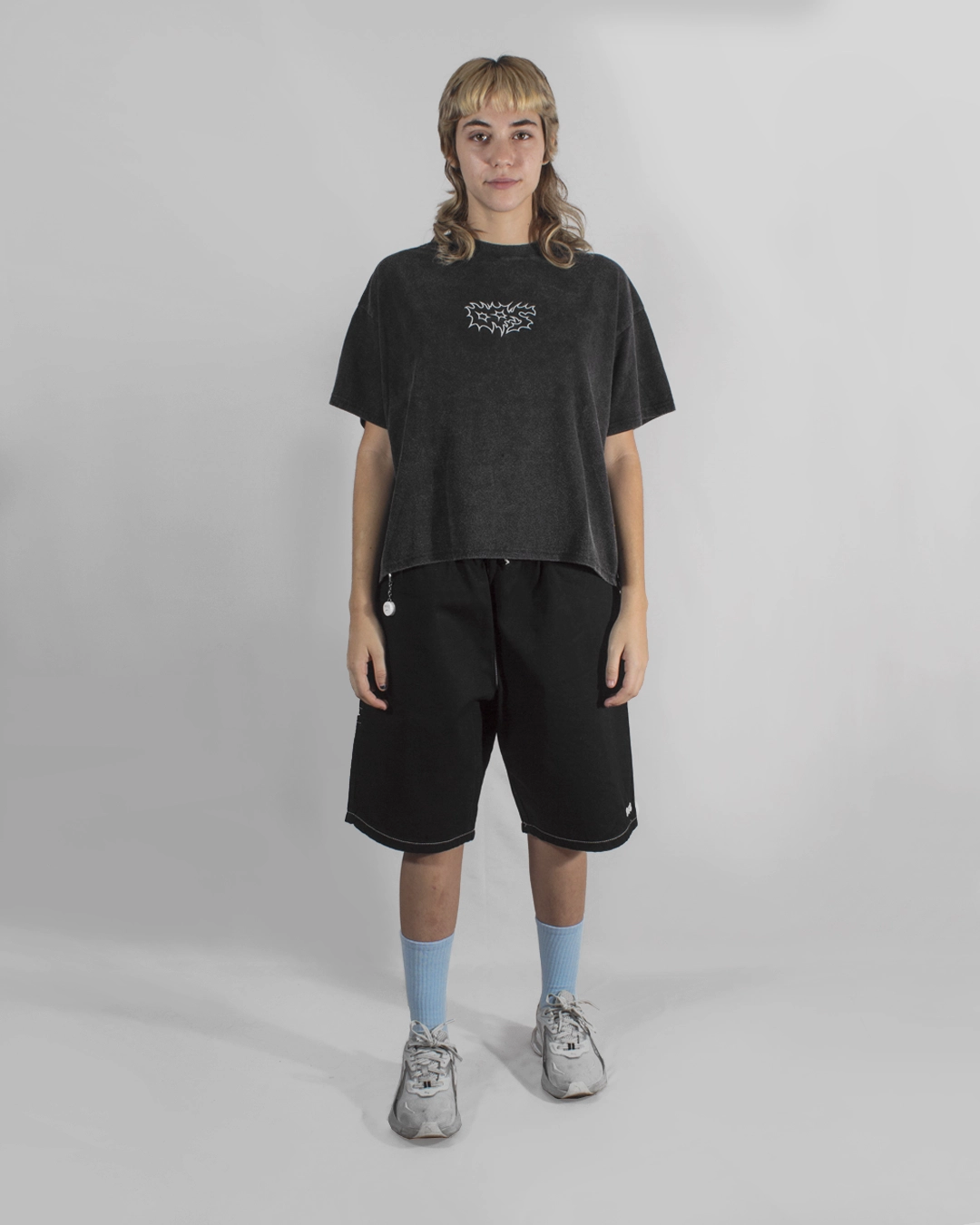 modelo outfit completo remera boxy fit bermuda negra skater urbano ancho